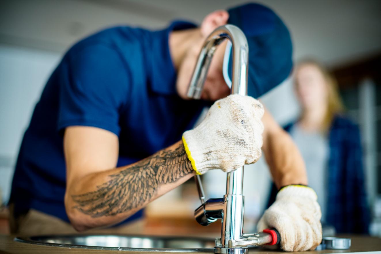 Professional plumber fixing sink